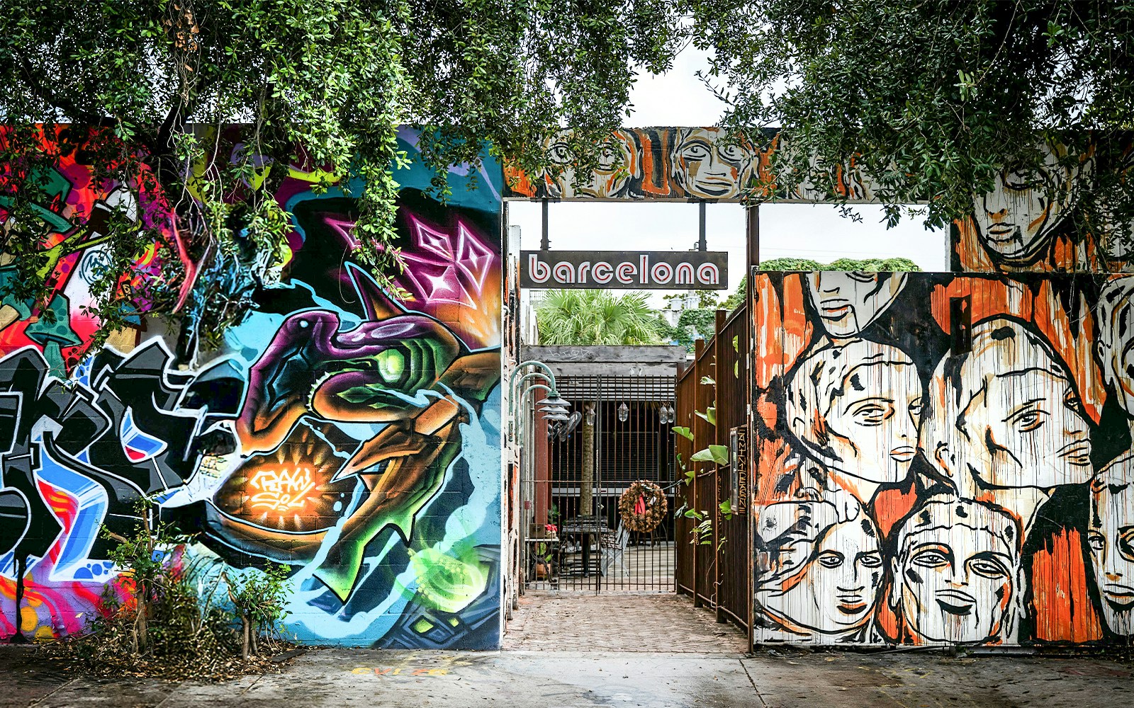 Colorful street art murals at Wynwood Walls, Miami, featuring abstract designs and faces.