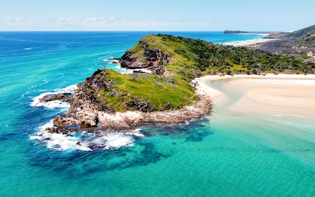 Aerial view of Fraser Island's coastline, K'gari, with turquoise waters and sandy beaches.