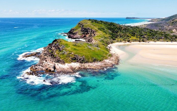 Aerial view of Fraser Island's coastline, K'gari, with turquoise waters and sandy beaches.