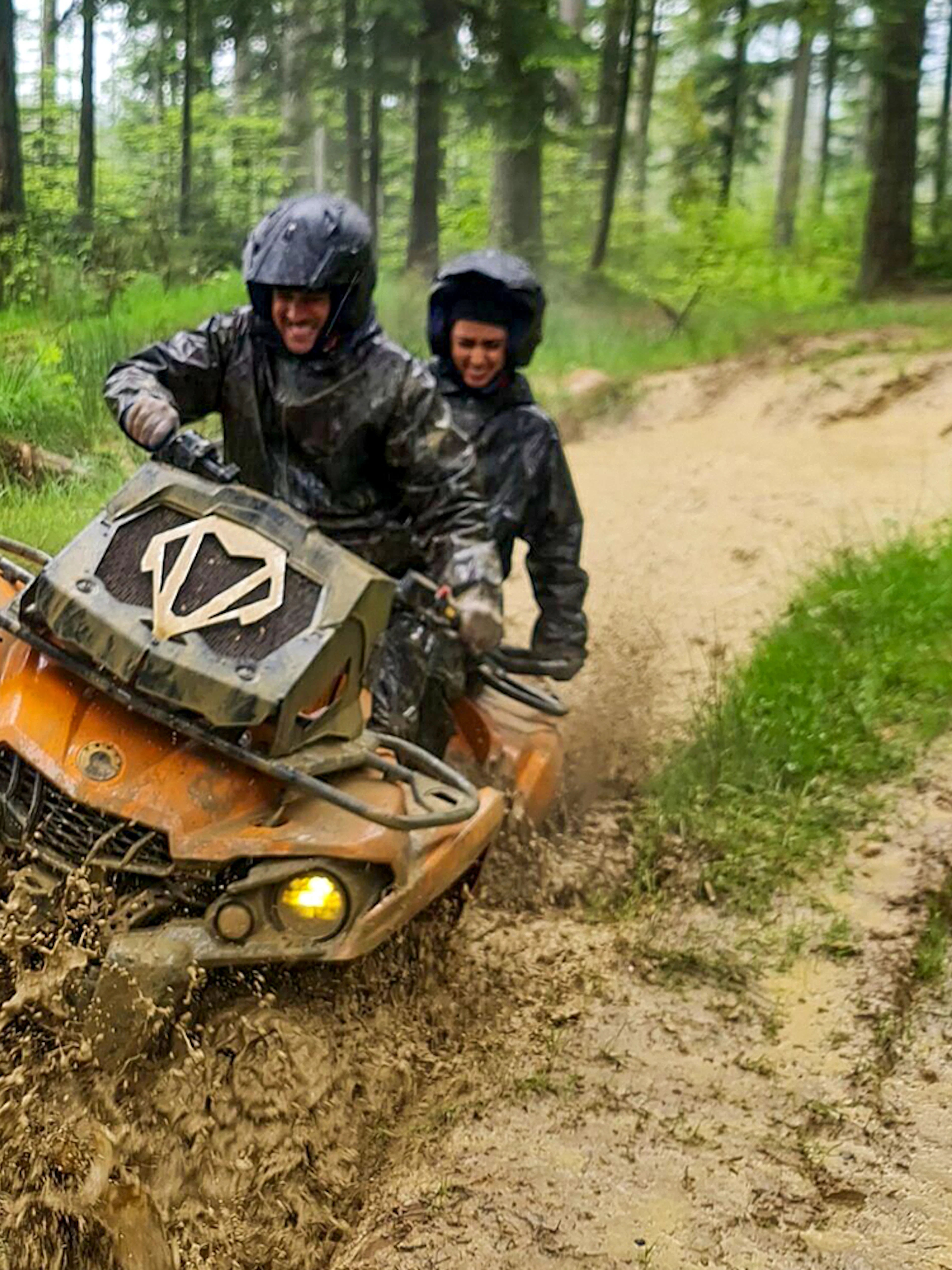 Visitors riding a quad bike through muddy forest trail in Zakopane.
