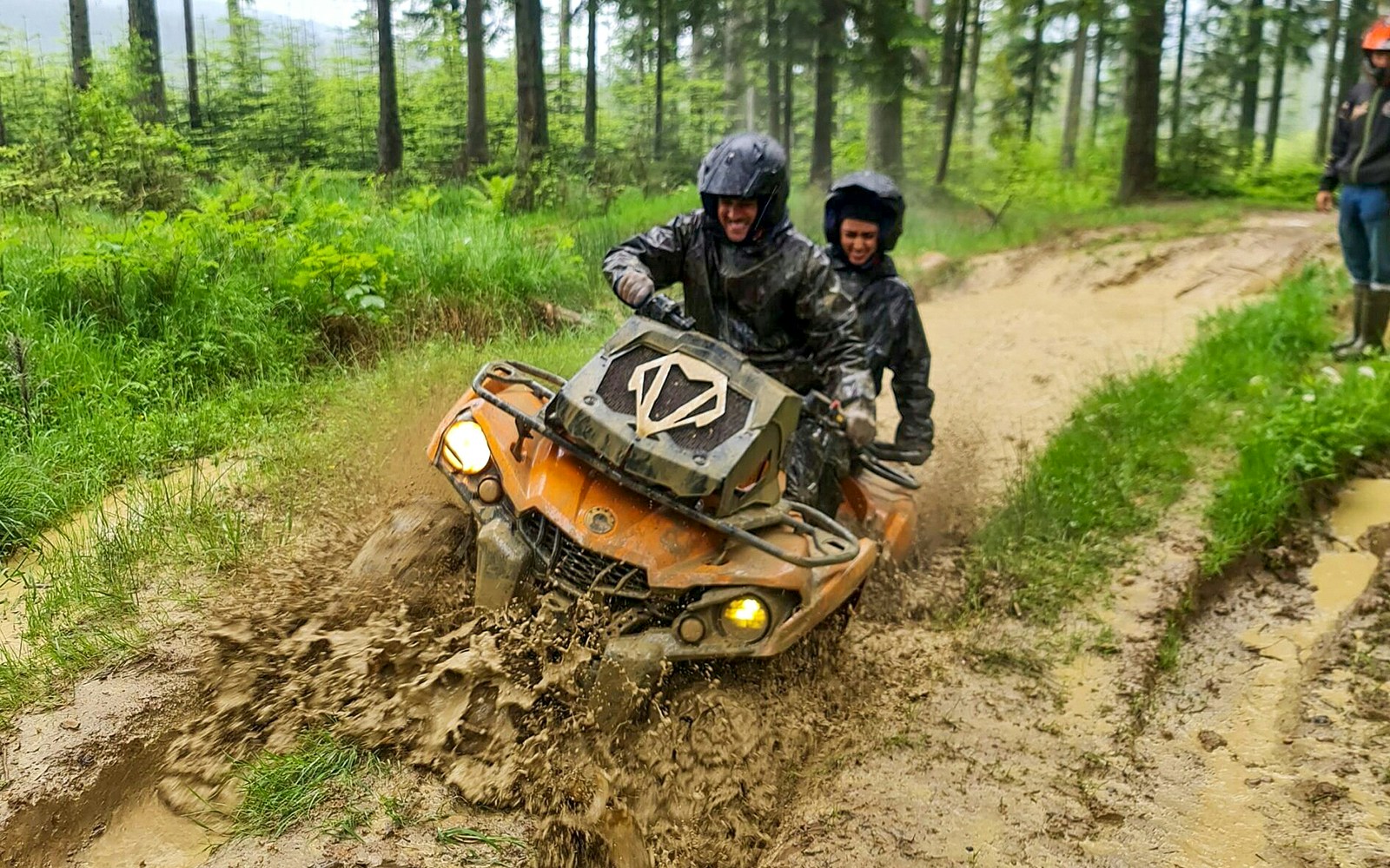 Visitors riding a quad bike through muddy forest trail in Zakopane.