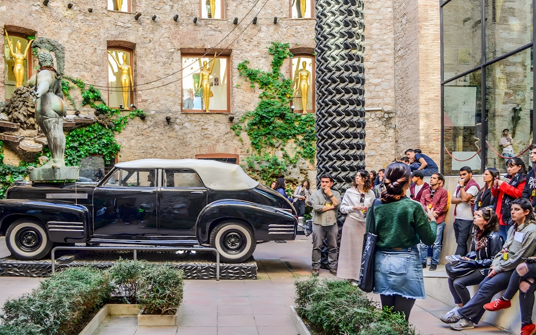 Tourists with guide in outdoor area of Dalí Theatre and Museum, Figueres, Spain.