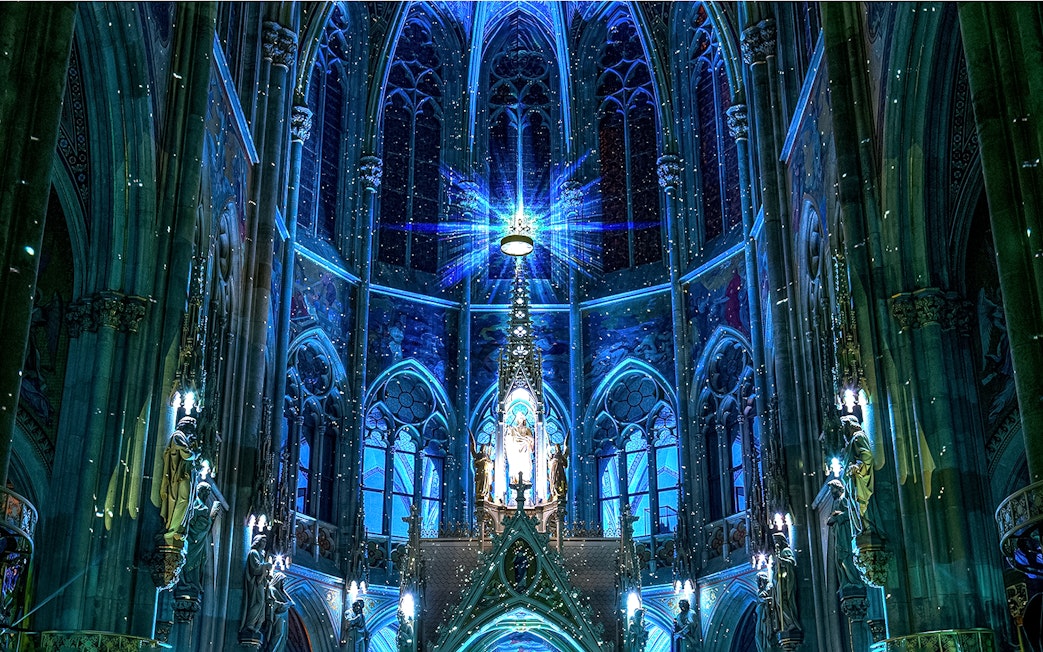 Votivkirche interior with blue lighting and ornate stained glass, Vienna.