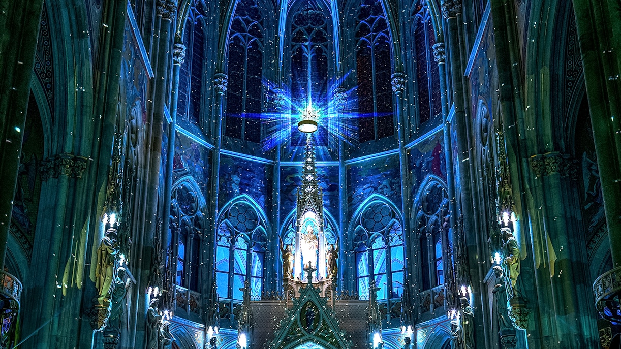 Votivkirche interior with blue lighting and ornate stained glass, Vienna.