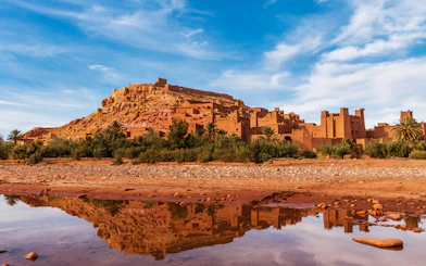 Tourists exploring Ait Benhaddou's historic kasbahs in Ouarzazate, Morocco.