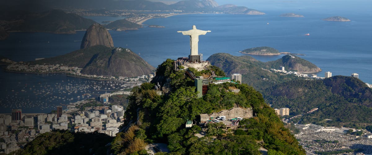 Christ the Redeemer statue overlooking Rio de Janeiro, Brazil, with Sugarloaf Mountain in the background.