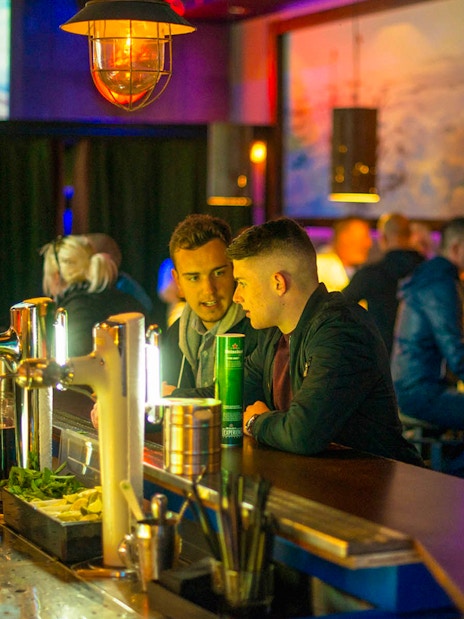 Bar scene at Icebar Amsterdam with patrons enjoying drinks.