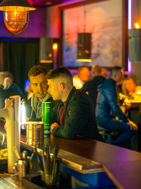 Bar scene at Icebar Amsterdam with patrons enjoying drinks.