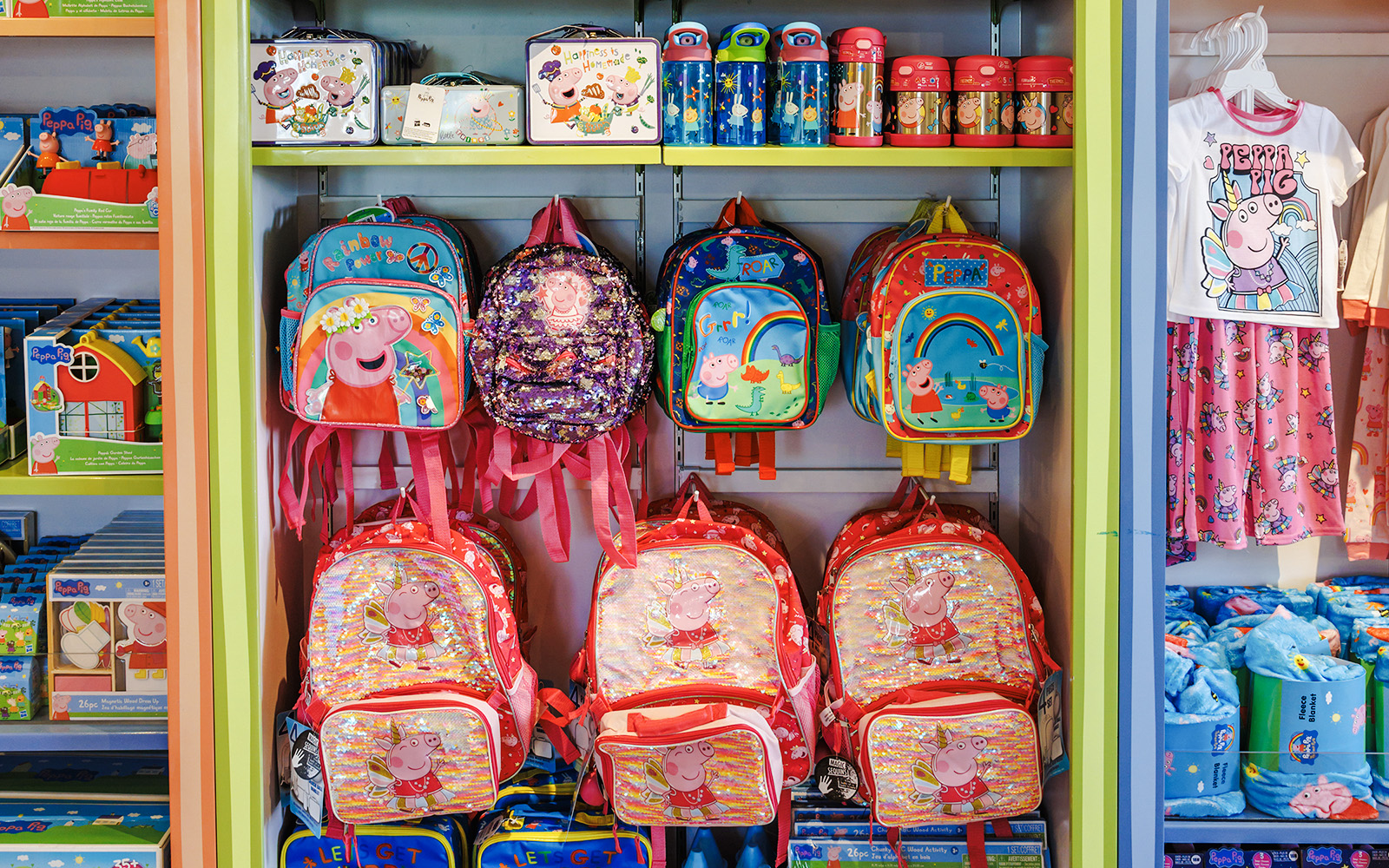 Peppa Pig merchandise display with backpacks and clothing at Peppa Pig Theme Park, Florida.