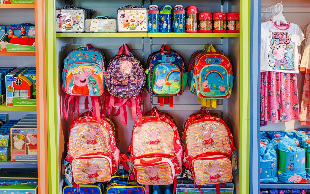Peppa Pig merchandise display with backpacks and clothing at Peppa Pig Theme Park, Florida.