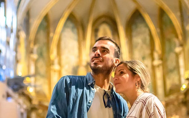 Couple admiring architecture inside Montserrat Monastery, Spain.