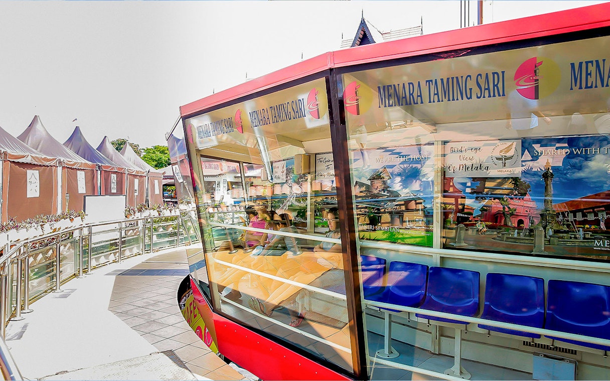 Menara Taming Sari observation deck with seated visitors in Melaka, Malaysia.