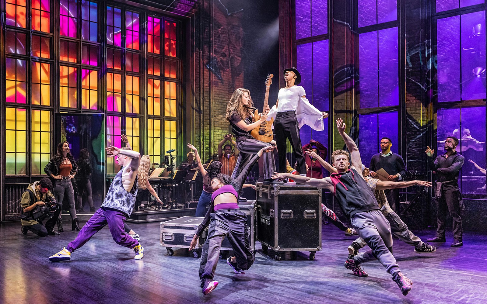 Performers dancing energetically on stage during MJ The Musical.