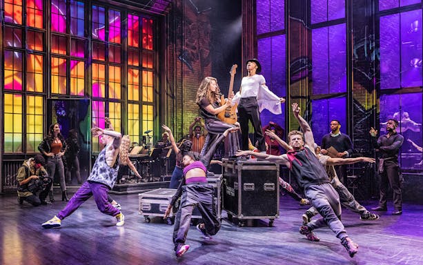 Performers dancing energetically on stage during MJ The Musical.