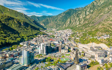 Aerial view of Andorra la Vella with surrounding mountains and cityscape.
