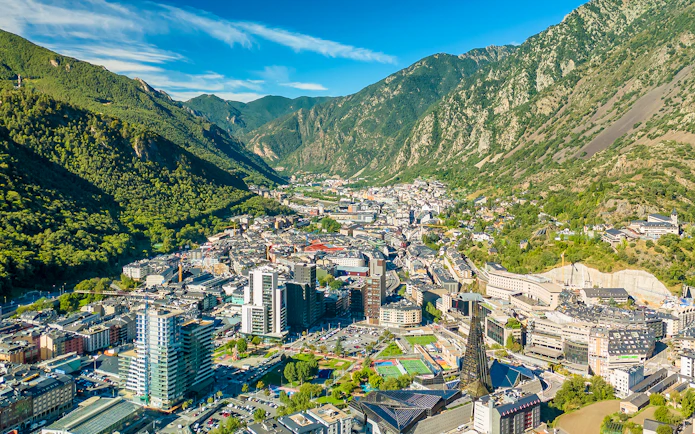 Aerial view of Andorra la Vella with surrounding mountains and cityscape.