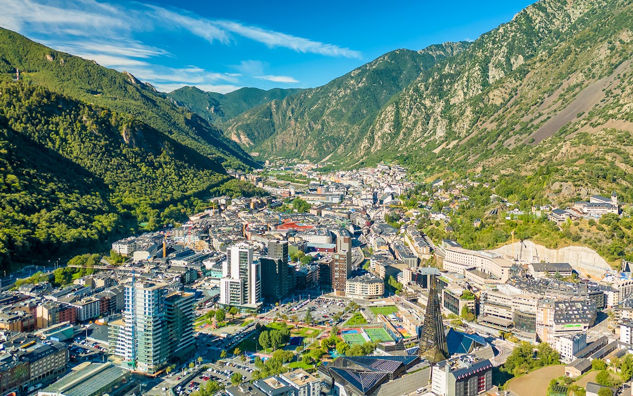 Aerial view of Andorra la Vella with surrounding mountains and cityscape.