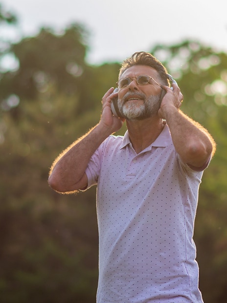 Man enjoying audio guide outdoors on Loch Ness and The Highlands day trip.