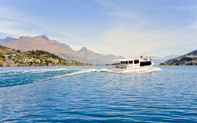 Tour boat cruising on Lake Wakatipu with Queenstown mountains in the background.