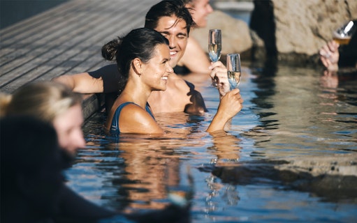 People enjoying drinks in Hvammsvík Hot Spring near Reykjavík.