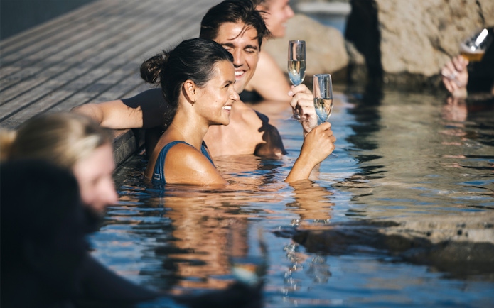 People enjoying drinks in Hvammsvík Hot Spring near Reykjavík.