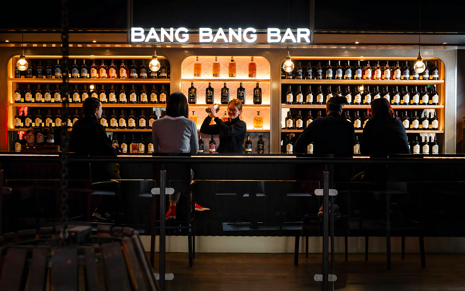 Bartender serving drinks at Teeling Whiskey Distillery bar with patrons seated.