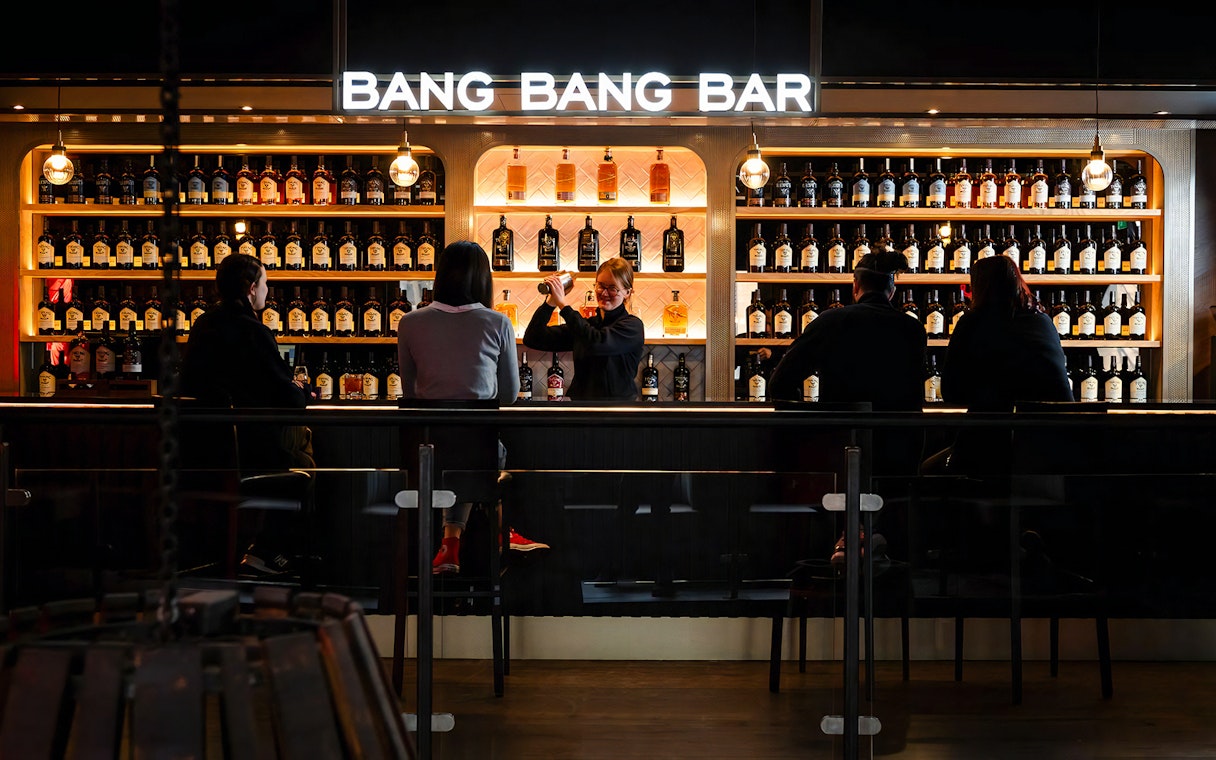 Bartender serving drinks at Teeling Whiskey Distillery bar with patrons seated.