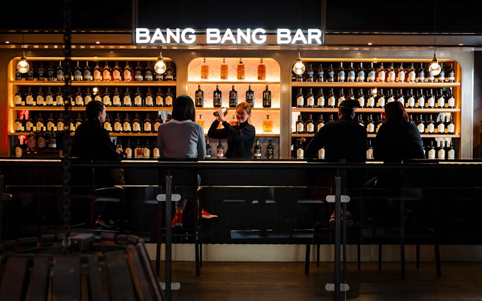 Bartender serving drinks at Teeling Whiskey Distillery bar with patrons seated.