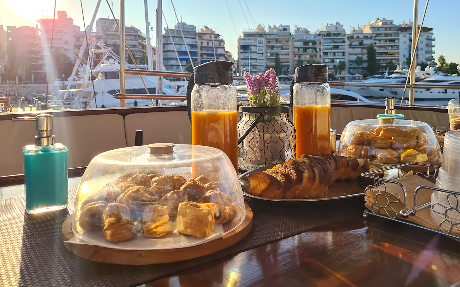 Breakfast setup on a yacht with pastries and juice during Athens cruise.