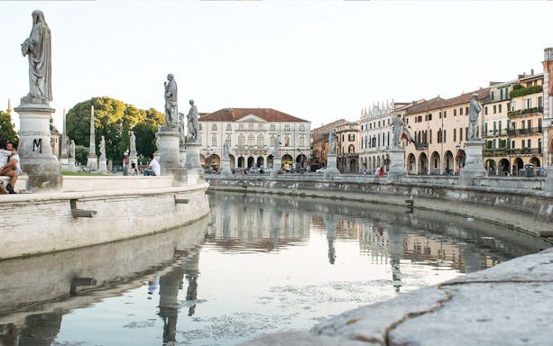 Prato della Valle with statues and canal in Padua, Italy.