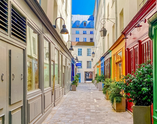 Le Marais street in Paris with historic buildings and cobblestone path.