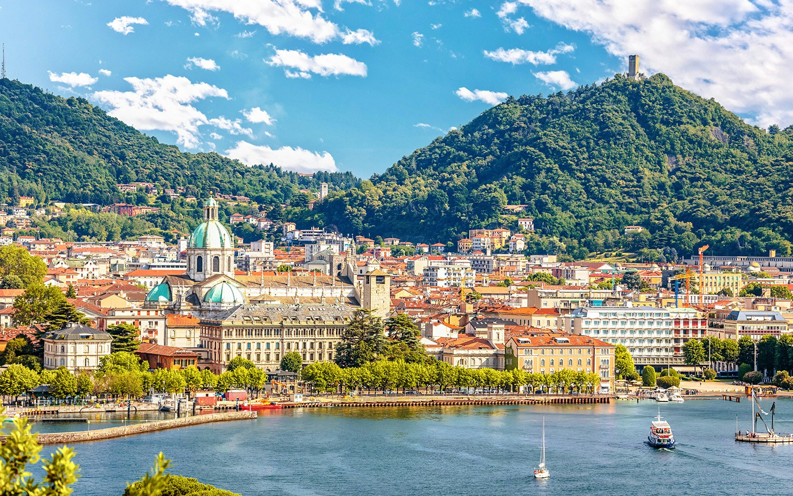 Como City skyline with cathedral and lake, surrounded by lush hills, Italy.