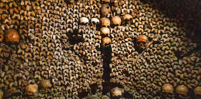 Skulls and bones arranged in the Paris Catacombs during a guided tour.