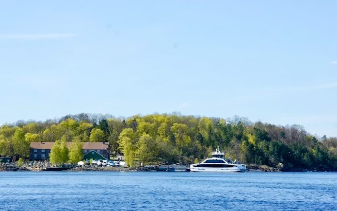 Ferry docked at an island with lush trees during Oslofjord Island Hopping Tour.