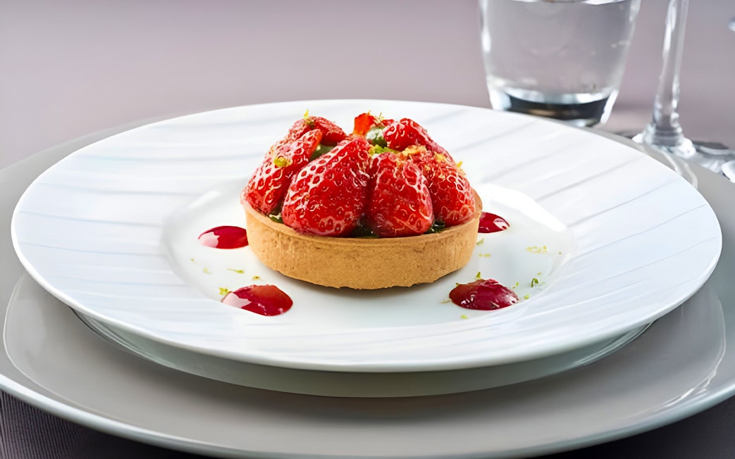 Strawberry tart served on a white plate during Bateaux Parisiens lunch cruise in Paris.