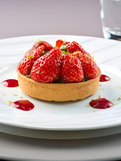 Strawberry tart served on a white plate during Bateaux Parisiens lunch cruise in Paris.