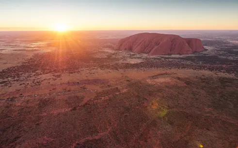 Aerial view of Uluru at sunrise during a 25-minute helicopter tour in Australia.
