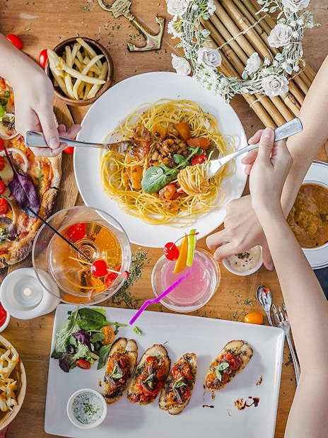 Lunch spread at Royal Albatross Dockside Bar, Singapore with pizza, pasta, and cocktails.