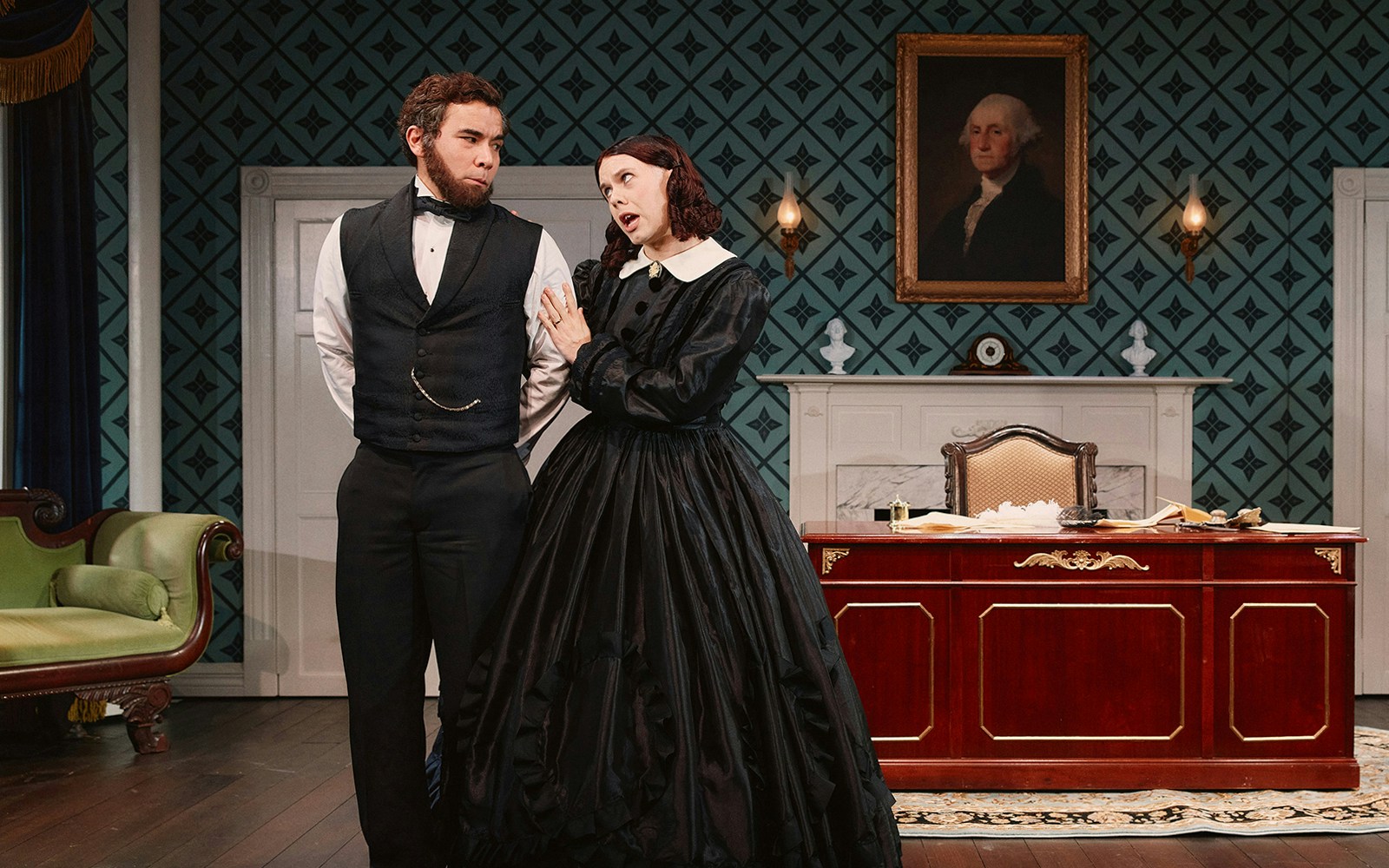 Two actors in period costumes perform a scene in a vintage office setting for "Oh, Mary!