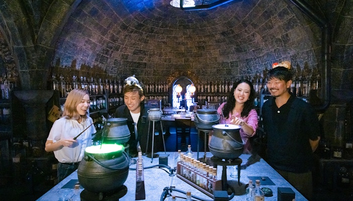 People crafting potions in a Hogwarts-themed room at Warner Bros. Studio Tour Tokyo.