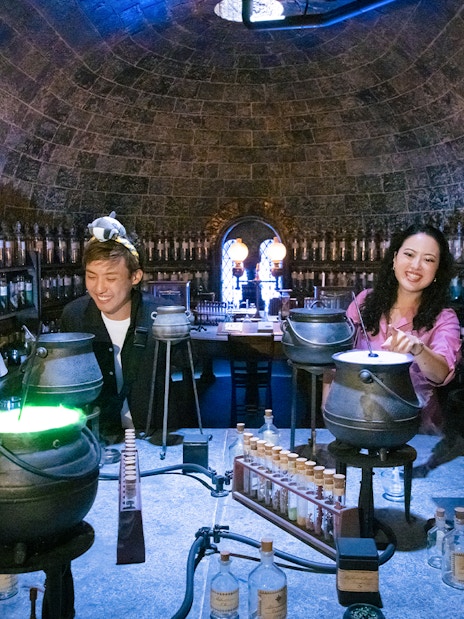 People crafting potions in a Hogwarts-themed room at Warner Bros. Studio Tour Tokyo.