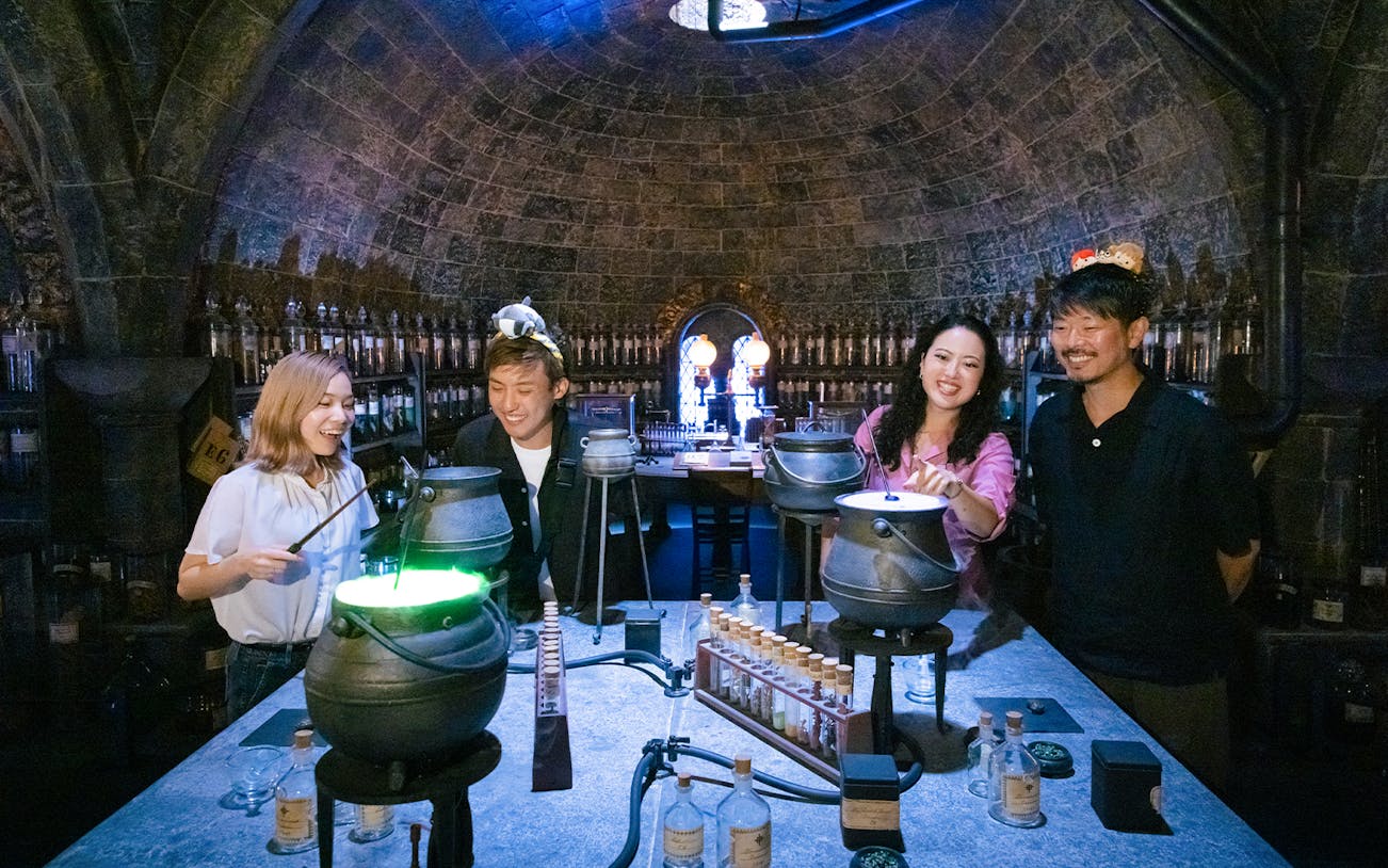 People crafting potions in a Hogwarts-themed room at Warner Bros. Studio Tour Tokyo.
