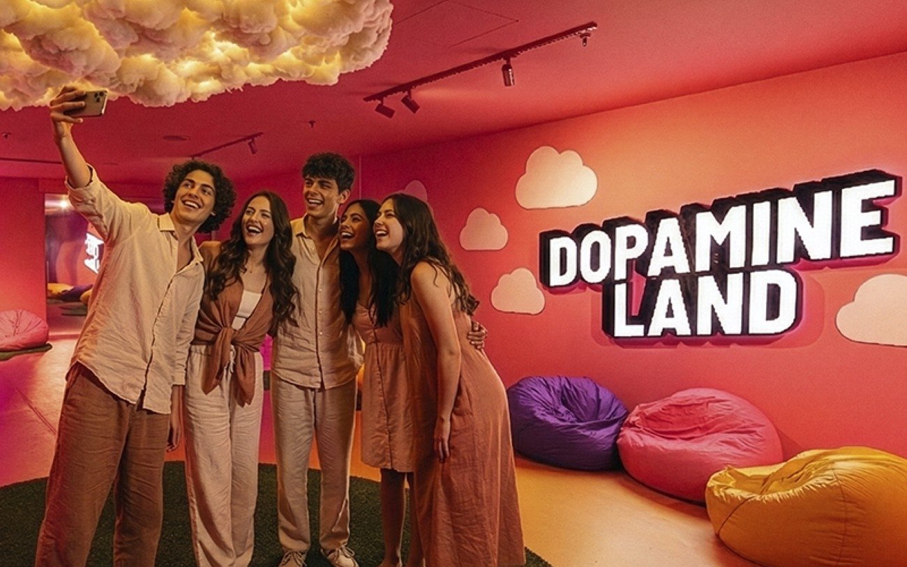 Friends taking a selfie at Dopamine Land, Dubai with colorful bean bags and cloud decor.
