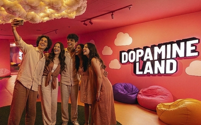 Friends taking a selfie at Dopamine Land, Dubai with colorful bean bags and cloud decor.