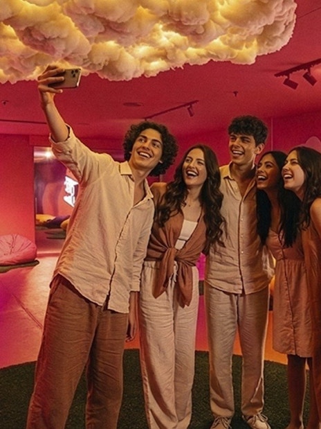 Friends taking a selfie at Dopamine Land, Dubai with colorful bean bags and cloud decor.