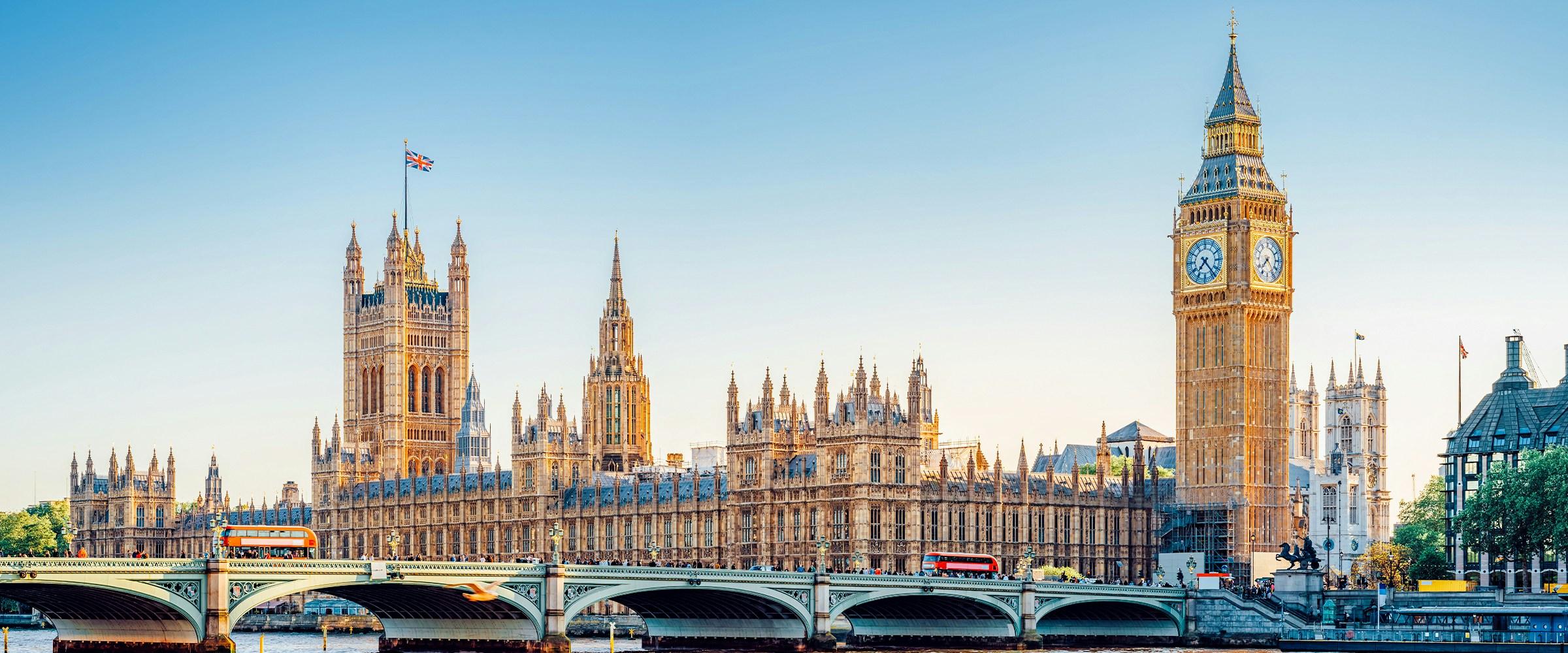 Westminster Bridge and Big Ben in London with red double-decker buses.