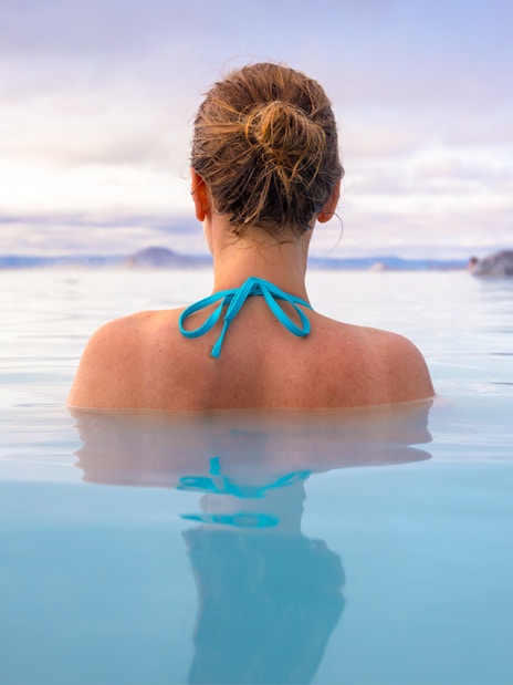Person relaxing in Myvatn Nature Baths, Iceland, surrounded by geothermal waters.