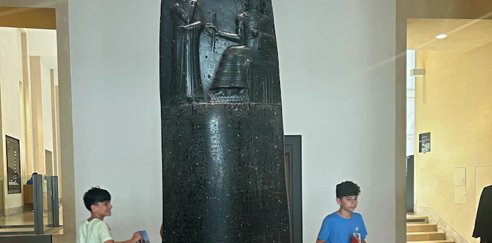 Code of Hammurabi stele displayed in a museum setting.