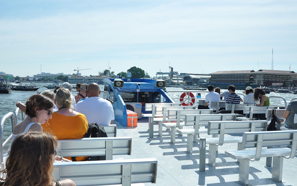 Passengers seated on a boat cruising the Chao Phraya River in Bangkok.