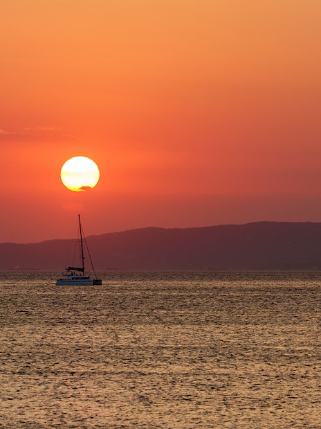 Sailboat on the sea at sunset in Athens Riviera, Greece.